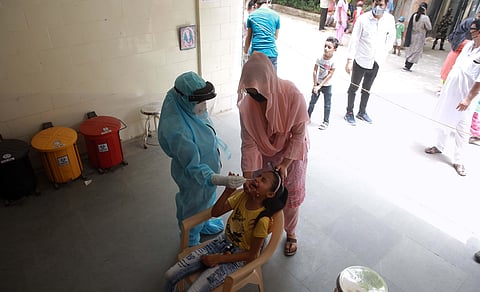 A health technician takes sample from a girl for COVID-19 testing via Rapid Antigen Kits in New Delhi on Friday.  (Photo | Shekhar Yadav/EPS)