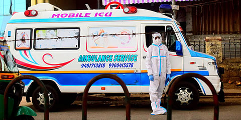An ambulance driver wearing PPE waits near Kempegowda Bus Station in Bengaluru on Sunday. (Photo| Pandarinath B, EPS)