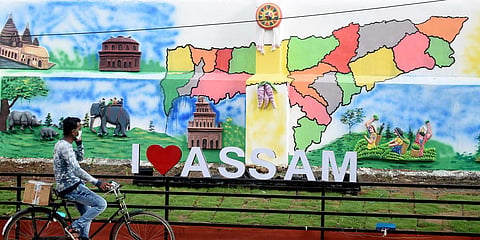 A man rides his cycle past a mural during the ongoing COVID-19 lockdown in Guwahati. (Photo| ANI)