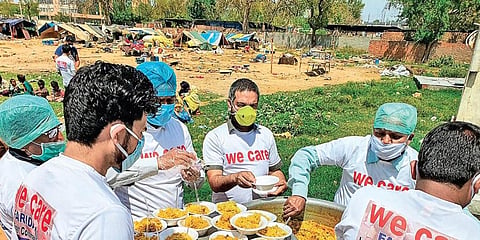 We Care volunteers distributing food.