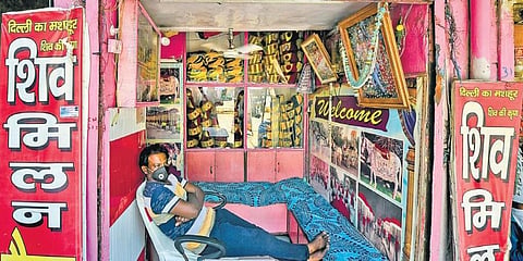A shopkeeper waits for customers at his wedding band shop in New Delhi. (Photo | PTI)
