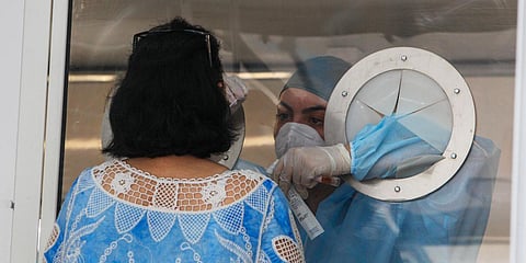 Medical staff takes a sample from a woman to test for COVID-19, at an apartment complex in Mondragone, Italy. (Photo| AP)