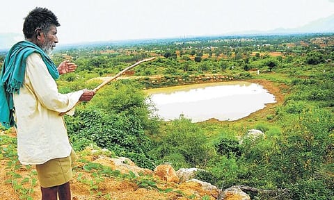 Kaamegowda stands near one of the ponds he built. The octogenarian has built  16 ponds on the barren Kundinibetta hill in Mandya district  | Pandarinath B