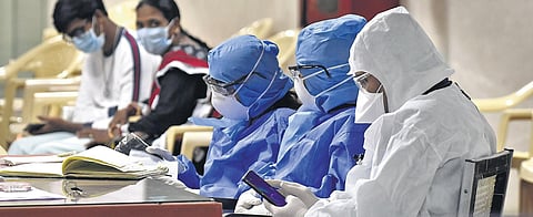 Gandhi Hospital staff at the help desk wearing safety gear, as citizens await COVID-19 tests. (File Photo | Vinay Madapu, EPS)