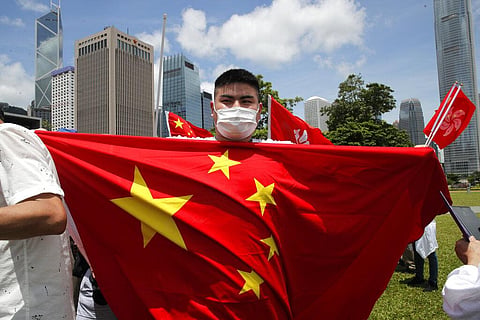 A pro-China supporter holds a Chinese national flag during a rally to celebrate the approval of a national security law for Hong Kong, in Hong Kong, Tuesday, June 30, 2020. (Photo | AP)