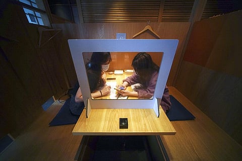 Customers order drinks and food with their phone through plastic protector against the new coronavirus infection at Kichiri, an 'izakaya' restaurant chain in Tokyo Thursday, June 4, 2020. (Photo | AP)
