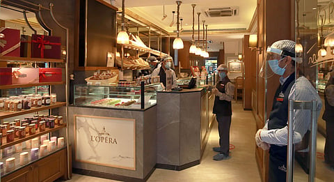 A restaurant worker wearing a protective face mask and shield against the spread of coronavirus waits for customers at L'Opera restaurant in New Delhi on Saturday.  (Photo | Shekhar Yadav/EPS)