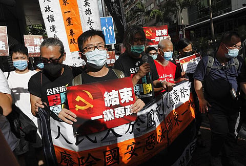 Pro-democracy protesters shout slogans ' Stop One Party Rolling' as they march toward the flag raising ceremony marking the anniversary of the Hong Kong handover to China, in Hong Kong Wednesday, July 1, 2020. Hong Kong marked the 23rd anniversary of its 