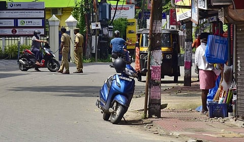 Police controlling the people who are visiting the shops in the containment zone at Palarivattom area in Kochi. (Photo | Albin Mathew /EPS)
