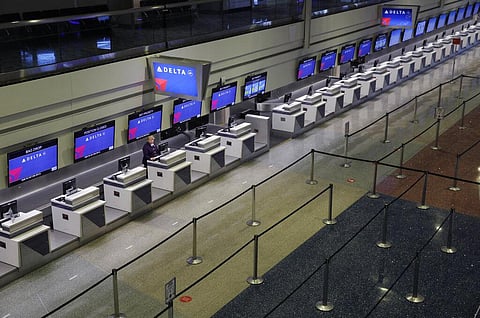 In this April 21, 2020, file photo, a lone person works at the Delta airlines check-in desk at McCarran International airport in Las Vegas. (Photo | AP)
