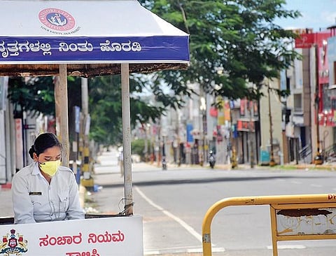 A traffic police constable wears a mask while on duty at DD Urs Road, Mysuru, during Sunday’s state-wide lockdown | Udayshankar S