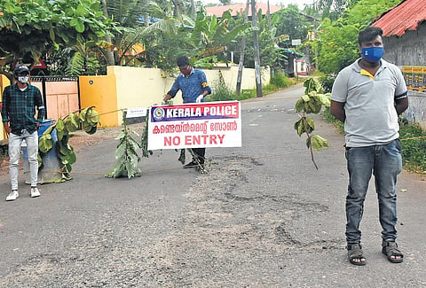 Volunteers of Kerala Sannadha Sena stand guard after blocking the road at Vilayilmoola in Kadakavoor panchayat in Thiruvananthapuram, a coastal area which was declared a critical containment zone till July 28 | B P DEEPU