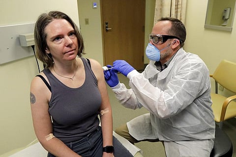 Pharmacist gives Jennifer Haller, left, the first shot in the first-stage safety study clinical trial of a potential vaccine for COVID-19 (Photo | AP)