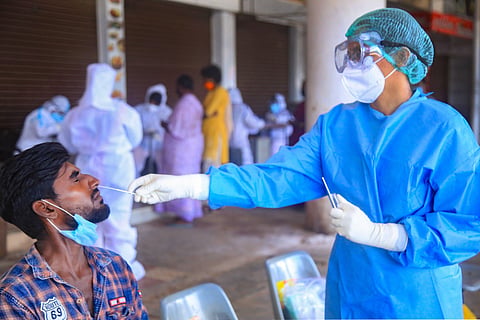 A medic collects a sample from a vegetable vendor for COVID-19 test at Vadaserry bus stand after some positive cases during Unlock 2.0 in Kanyakumari district Thursday July 2 2020. (Photo | PTI)