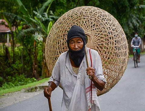 An elderly man walks to a market to sell bamboo baskets during ongoing COVID-19 lockdown at Baganpara in Baksa district of Assam. (File Photo | PTI)