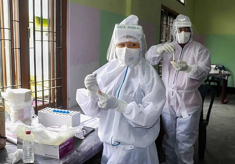 Health workers wearing PPE hold samples for COVID-19 rapid antigen testing. (Photo | PTI)