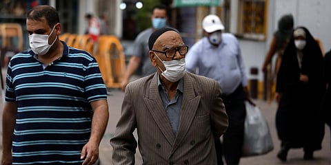 People wearing protective face masks to help prevent the spread of the coronavirus walk on a sidewalk in the city of Zanjan in Iran. (Photo| AP)