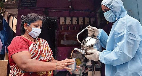 A city corporation staff giving ‘kabasura kudineer’ (a herbal concoction), which  is believed to boost immunity, to a resident in Porur on Sunday | P Jawahar