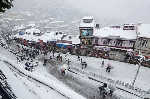 People walk on snow covered roads amid heavy snowfall in Shimla. (File | PTI)