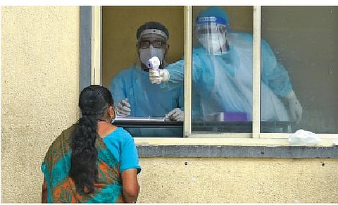 Staff at the Bowring and Lady Curzon Hospital screen a woman before allowing her to proceed to the OPD section, in Bengaluru on Wednesday | VINOD KUMAR T