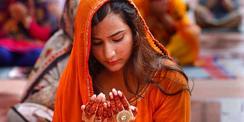 Muslims worldwide marked the start of the Eid al-Adha holiday amid a global pandemic that has impacted nearly every aspect of this year's pilgrimage and celebrations. IN PIC: A young woman prays during Eid al-Adha prayers at the historical Badshahi Mosque in Lahore, Pakistan. (Photo | AP)