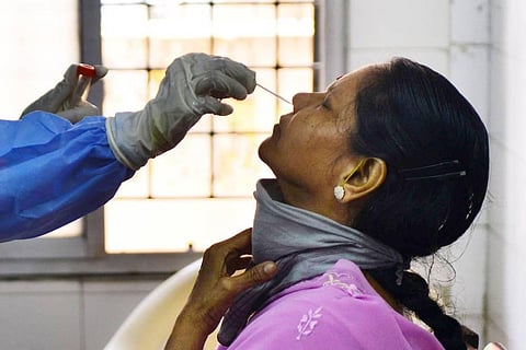 A health worker taking nasal swab from a woman for Covid-19 test at a Public Health Laboratory and Health Care Center. (Photo | Debdatta Mallick, EPS)