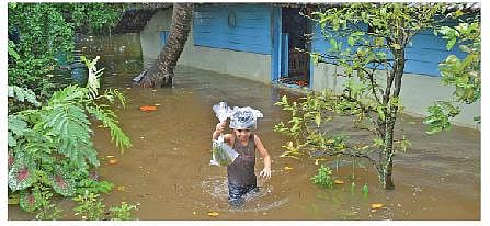 A boy walking through floodwater after his house was submerged in  Manippuzha near Kottayam | Express