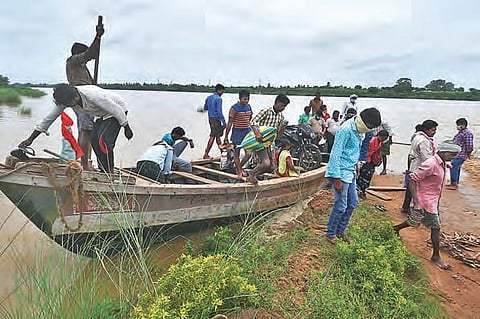 As the road leading to Pamula Lanka is submerged in water, villagers  use a mechanised boat to go to the other side of a flooded stream near Vijayawada. (Photo | Prasant Madugula, EPS)