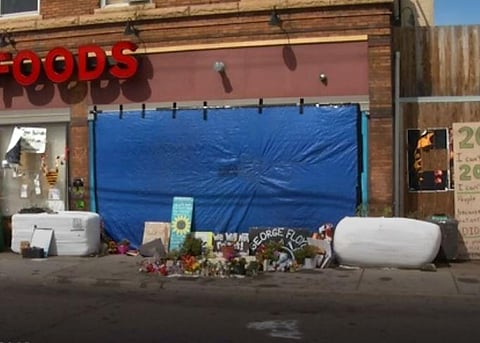 The mural was sprayed with black paint and is now covered by a blue tarp. (Photo | AP)