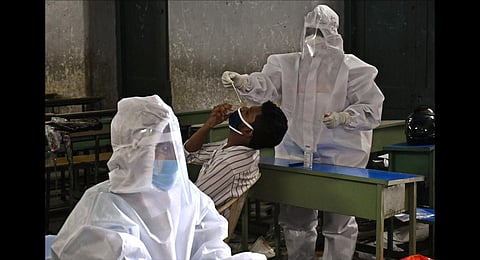 A health worker collects the swab sample for COVID testing in a classroom. (Photo | Prasant Madugula, EPS)