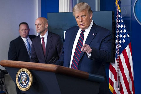 President Donald Trump speaks, accompanied by Food and Drug Administration Commissioner Dr. Stephen Hahn, center, during a media briefing. (Photo | AP)