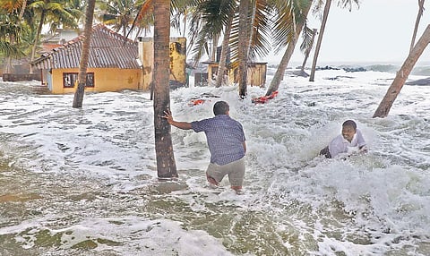 Two persons wading through the water  thrown to the shore by strong waves at Chellanam (File photo)
