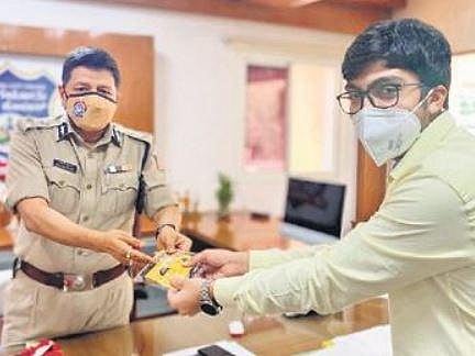 Amaan Asim hands over a sample of the mask to Police Commissioner Kamal Pant