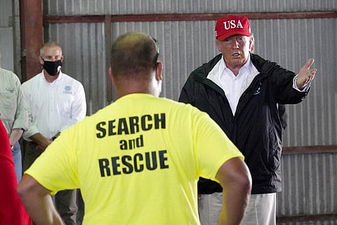 President Donald Trump speaks with first responders as he tours a warehouse being used as a distribution point for relief aid after Hurricane Laura hit the area. (Photo | AP)