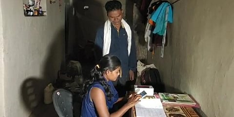 Anand Nageshiya watches his daughter Yamini use smatphone.