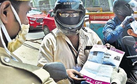 A man displaying a document to police at a checkpost. (Photo | Ashwin Prasath)