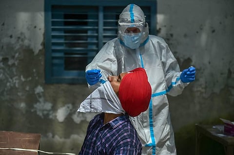 A health care worker collecting samples for COVID-19 testing in New Delhi. (Photo | PTI)