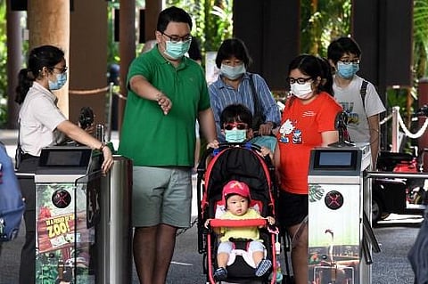 Members of a family wearing face masks enter Jurong Bird Park for a visit in Singapore on July 24, 2020. (Photo | AFP)