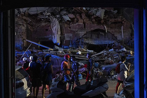 People walk by damaged buildings at a neighborhood near the scene of Tuesday's explosion that hit the seaport of Beirut, Lebanon, Friday, Aug. 7, 2020. (Photo | AP)