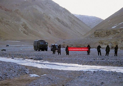 In this May 5, 2013, file photo, Chinese troop hold a banner which reads: 'You've crossed the border, please go back,' in Ladakh, India. (Photo | AP)