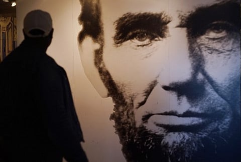A visitor to an exhibit at the Lincoln Memorial walks past an image of Abraham Lincoln on April 1, 2015 in Washington, DC. (Photo | AFP)