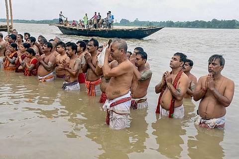 Devotees perform 'Tarpan' ritual on the bank of Ganga river on the occasion of Mahalaya in Murshidabad district Thursday Sept. 17 2020.  (Photo | PTI)