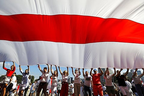 Opposition supporters wave a huge old Belarusian national flag as they rally in the center of Minsk, Belarus. (File Photo | AP)