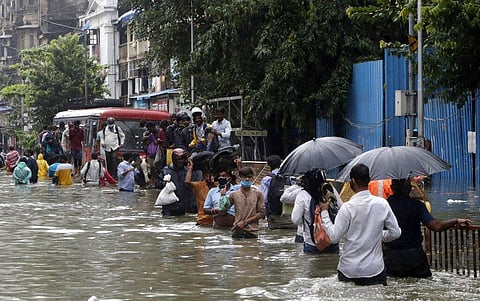 People walk through a water logged street after heavy rain in Mumbai, India, Wednesday, Sept. 23, 2020.  (Photo | AP)