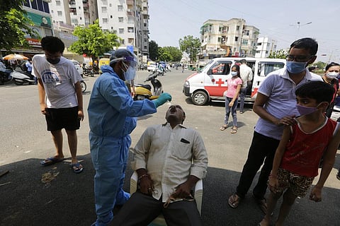 A health worker takes a nasal swab sample to test for COVID-19 test at a facility erected to screen people in Ahmedabad, India, Tuesday, Sept. 22, 2020. (Photo | AP)
