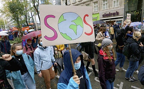 Environmental activists wearing face masks to help protect against the spread of the coronavirus stage during a rally marking the Global Day of Climate Action in Vienna, Austria. (Photo | AP)