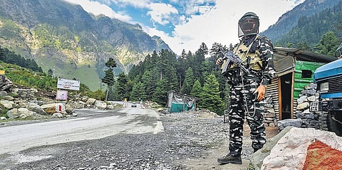 A security personnel stands guard along the Srinagar-Ladakh highway in Ganderbal district, central Kashmir, on Wednesday. (Photo | PTI)