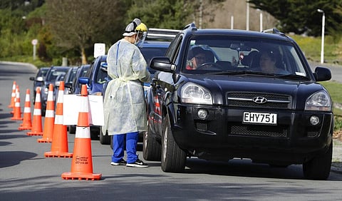 Medical staff prepare take a COVID-19 test from a visitor to a drive through community based assessment centre in Christchurch, New Zealand. (Photo | AP)