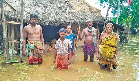 Villagers stand in knee-deep water at a flooded village in Jagatsinghpur district on Thursday | Express