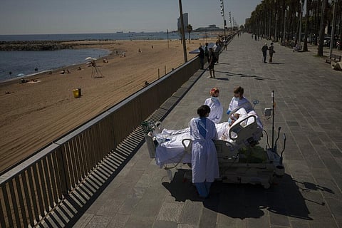 Francisco España, 60, is surrounded by members of his medical team as he looks at the Mediterranean sea from a promenade next to the 'Hospital del Mar' in Barcelona, Spain. (Photo | AP)